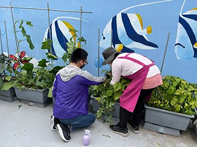 남성 참여자가 강사님과 같이 화분에 식물을 심고 있는 모습